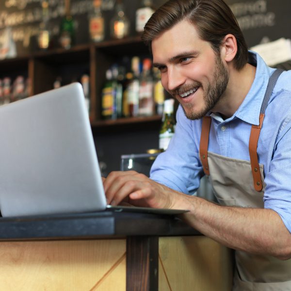 Barman aan de bar met laptop