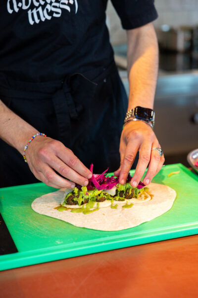 TOPPR van juni, Ghaith Alsheikh in de keuken van restaurant A Beautiful Mess voor het opmaken van een bord