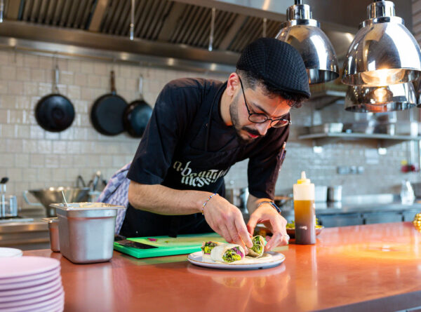 TOPPR van juni, Ghaith Alsheikh in de keuken van restaurant A Beautiful Mess voor het opmaken van een bord